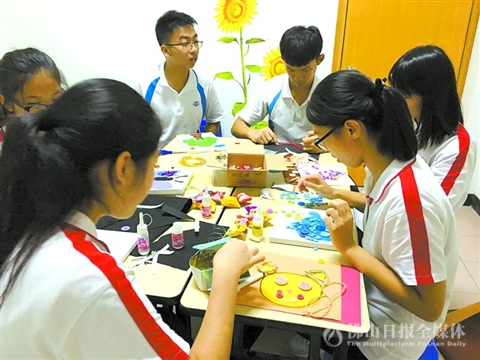 郑裕彤中学学生在参加驻校社工组织的“齐动手，扭一扭”花样艺术工作坊。