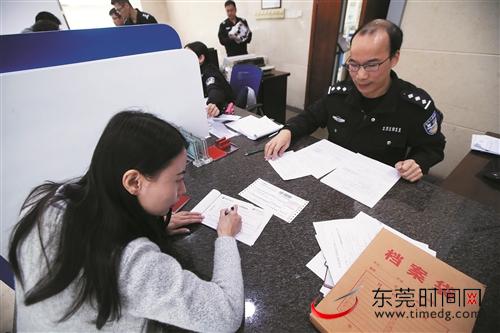在东城公安分局办事大厅,市民在填写邮递地址 记者 郑家雄 摄