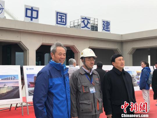 中交港珠澳大桥岛隧工程项目总工程师林鸣(左一)与专家学者们在港珠澳大桥东人工岛上合影留念 邓媛雯 摄