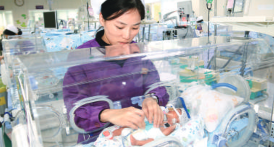 护士照顾三胞胎之一的婴儿。/珠江商报通讯员碧宁摄