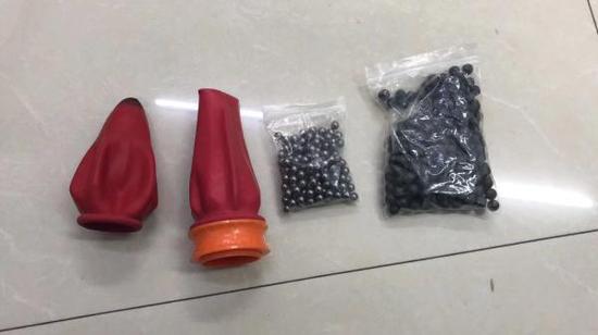 上海警方发现的用于打塑料BB弹的仿真枪2把、弹弓2把,以及钢珠、塑料BB弹等弹珠近百粒。 上海警方供图