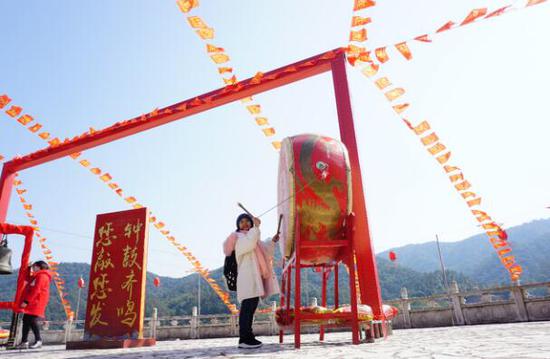 游客在飞霞山敲鼓祈福。