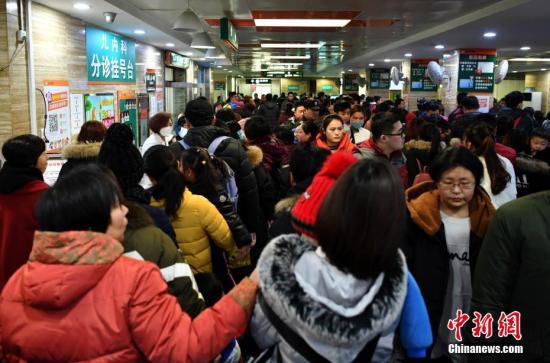 1月5日,河北省儿童医院呼吸科大厅内,抱着孩童前来看病的父母们摩肩接踵。中新社记者 翟羽佳 摄