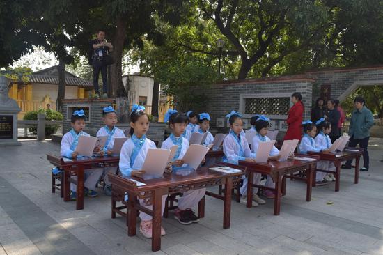 学生们正在树荫下熟读三字经