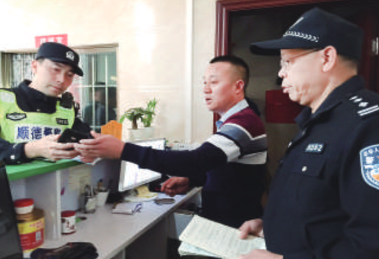 大良警方在旅店检查住宿登记记录。/珠江商报记者杜达雄摄