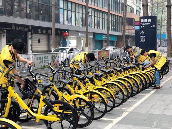图说:ofo运维人员正在对小黄车进行清洗