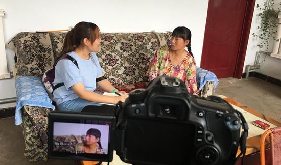 沈阳农业大学校媒记者王晨采访安泽县孔旺村贫困户、矿泉水厂工人郝大姐。上海海事大学 宋晨睿/摄