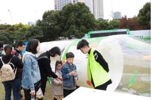 活动现场绘本场景区，小朋友们在家长的帮助下学习塑料污染相关知识。