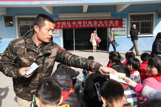 青少年防暴恐安全教官向孩子们发放安全知识手册