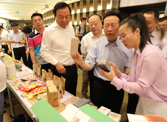 出席领导在电商扶贫品牌推介产品展示现场了解农特产品情况