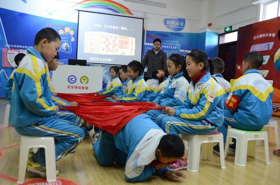 藏区学生在安全体验教室演练模拟烟道逃生