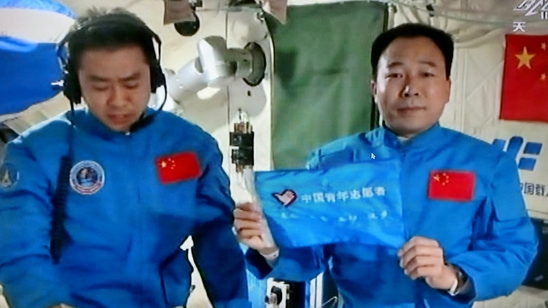 航天员在天宫二号空间实验室中展示中国青年志愿者旗帜