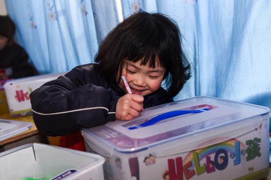 她在HELLO小孩爱心套餐箱子上郑重地写上自己的名字