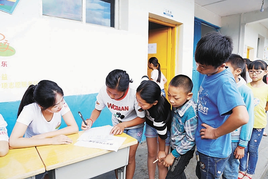 “快乐学校”志愿者到达贵州省习水县锡群同心小学开展志愿服务，学生纷纷来报名。扬州大学 高淑慧/摄