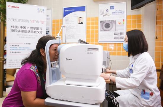 爱尔眼科医师使用佳能OCT光学相干断层扫描仪为患者进行眼底检查
