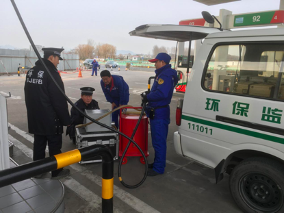图为房山区生态环境局检测人员对固村加油?#23621;?#27668;回收系统的密闭性、液阻、气液比进行日常检测。(房山区生态环境局供图)