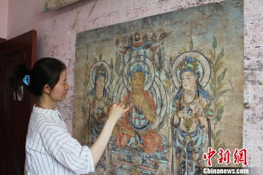 资料图。敦煌画师李玉在家中临摹莫高窟壁画。 徐雪 摄