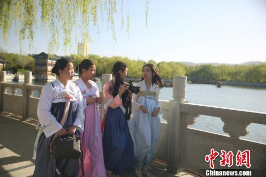 图为阳光明媚,身着汉服的青少年欣赏戈壁城市的美景。 陈兴明 摄