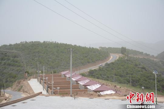 5月下旬,甘肃庆阳市环县合道镇杨坪沟村新修的柏油路旁边建起了新农村。 李文 摄