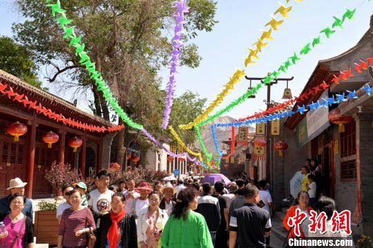 6月9日,兰州市西固区第三届文化旅游节暨河口古镇招商推介会在河口古镇举行。图为河口镇街道上游人如织。 郭炯 摄