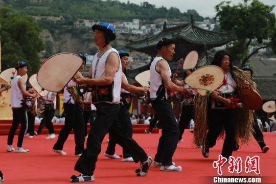表演时,“鼓头”一边敲锣一边指挥,其余舞者左手持鼓,右手握鼓鞭,鼓点变化多端,舞蹈动作粗狂。图为旋鼓舞表演现场。 张婧 摄
