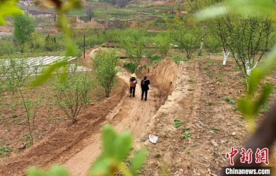 4月21日,甘肃陇南市武都区农民行走在正在修建的“花椒产业路”上。 闫姣 摄