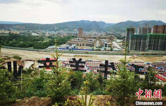 图为广河县康家模式的养殖区域与城区隔河相望。 艾庆龙 摄