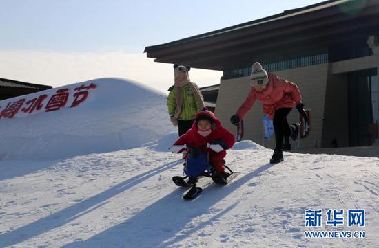 12月22日,游客在第三届敦煌文博冰雪节现场游玩。