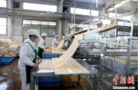 图为甘肃陇南市徽县,以豆制品精深加工为主的企业内,工人加工“致富豆”。 李文翠 摄