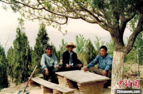 图为年轻时的汤学进(右一)与同伴在植树间隙休息,彼时山上的生态环境已有明显改善。(资料图) 受访人供图