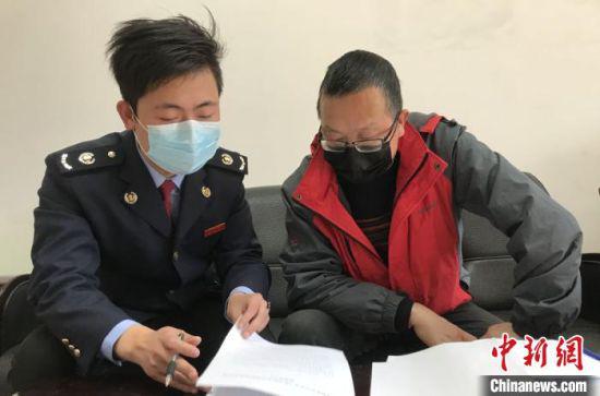 图为甘肃税务人员为纳税人进行政策辅导。 魏凌波 摄