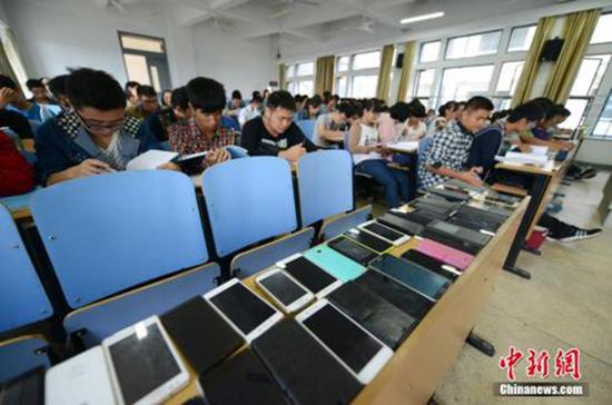中南大学软件学院的教室里,第一排座位上摆满了手机。为了治上课“低头族”,中南大学软件学院倡议学生先交手机再上课,此举得到众多师生的认可。 本文图均为 中新网 资料图
