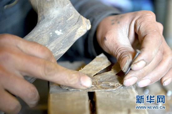 3月13日,潘明生的徒弟周治兵在甘肃省定西市渭源县新寨镇刻皮影。新华社记者李笑摄