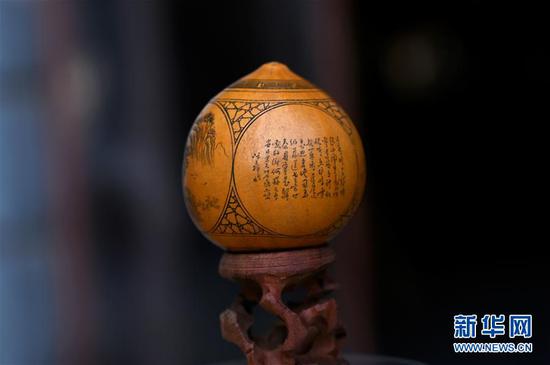 这是3月31日在兰州刻葫芦传习所拍摄的中国工艺美术大师阮文辉雕刻的葫芦作品《诗配画》。 新华社记者 刘洁 摄