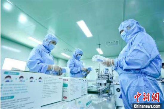 图为包装口罩。 王将 摄