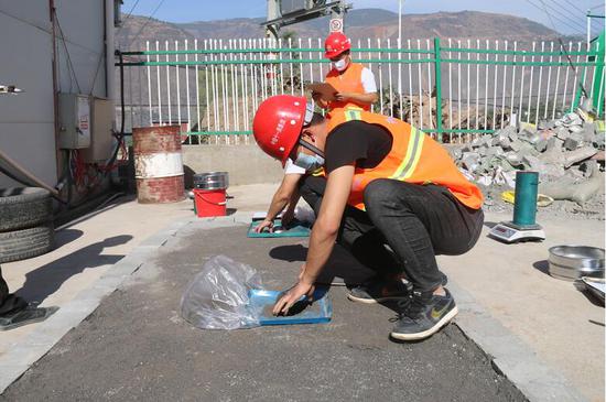 青年员工正在做路基灌砂法检测 摄影:程诚