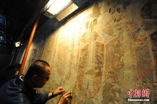 2015年,敦煌研究院壁画修复工作者在莫高窟“与时间赛跑”,争分夺秒救护国宝。 中新社记者 杨艳敏 摄
