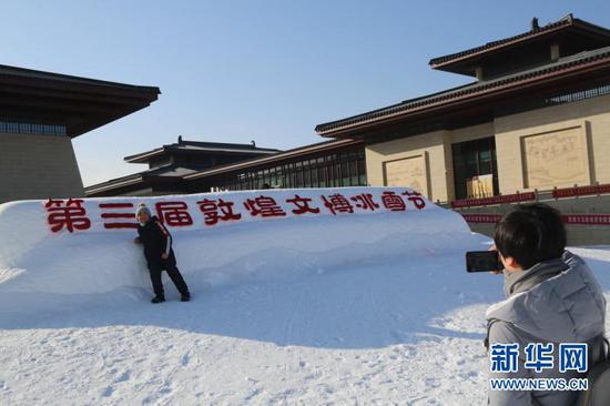 12月22日,游客在第三届敦煌文博冰雪节现场游玩。