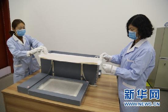 敦煌市档案馆工作人员展示修复后的唐代藏文写经。新华网发(张晓亮 摄)