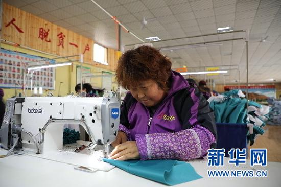 3月13日,余彩红正在缝纫服装。新华社记者张玉洁 摄