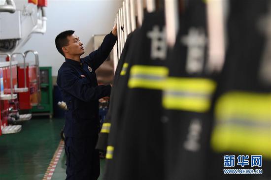 李志亮在整理消防救援服(4月11日摄)。 新华社记者 陈斌 摄