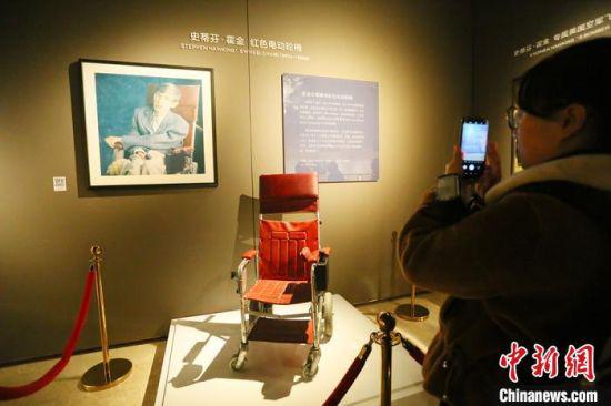 1月16日,参展民众拍照霍金早年乘坐的红色电动轮椅。 高康迪 摄