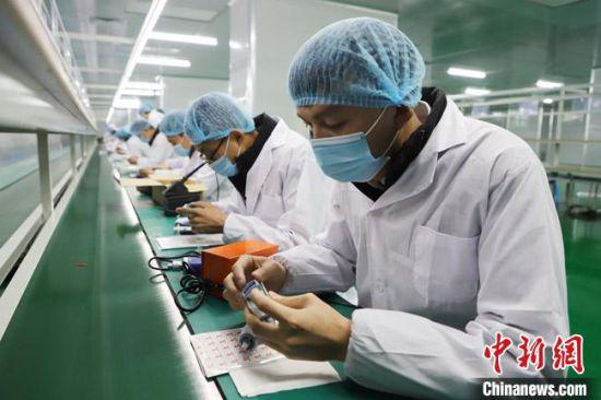 2月28日,甘肃省张掖市智能制造产业园内的海晟科技有限公司工人们在投产运营的电子测温枪生产线上作业。 刘枫 摄