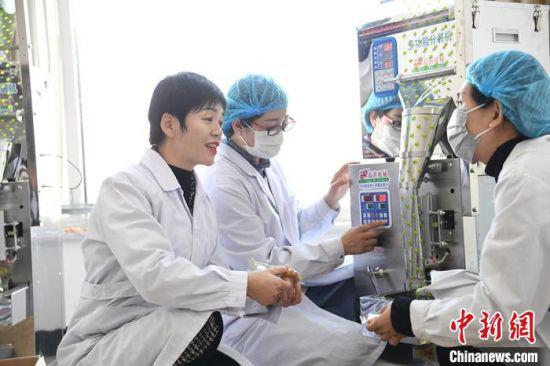 图为张瑜(左一)在生产车间与员工交流。 杨艳敏 摄