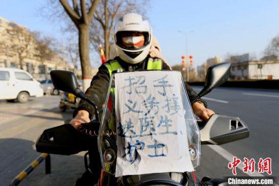 兰州“护医使者”摩托车前贴着“招手义务接送医生护士”的牌子。 高展 摄