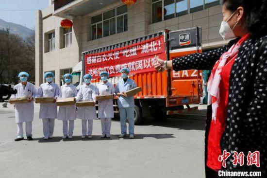 从湖北归来的医护人员合影时高呼:“之前我为湖北拼过命,现在我为湖北拼一单!“ 刘勇 摄