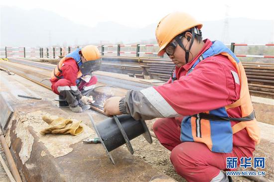 工人在临大高速公路大河家黄河大桥建设现场施工(11月4日摄)。