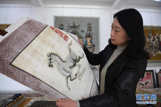 黄晶蓉在天水新天丝毯有限公司的成品展室查看丝毯成品(4月12日摄)。新华社记者 陈斌 摄