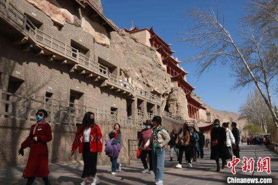 图为4月中旬,游客在敦煌莫高窟参观游玩。 张晓亮 摄