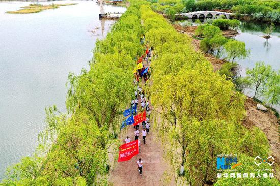 5月10日,健走队伍穿过高台黑河湿地。新华网发 (郑耀德 摄)